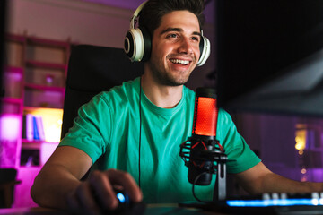 Image of caucasian happy man playing video game on computer