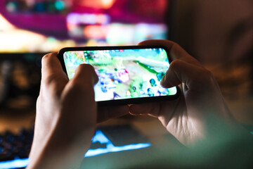 Image closeup of focused man playing video game on mobile phone - obrazy, fototapety, plakaty