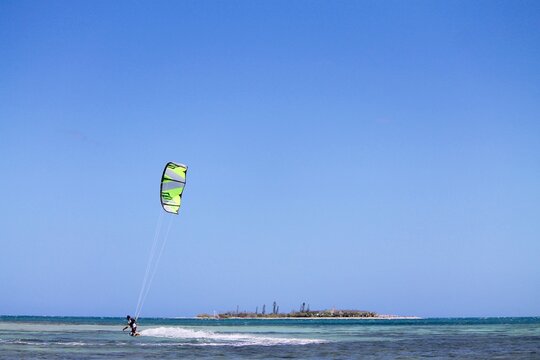 Paraplane flying near the waters on background of an empty sky