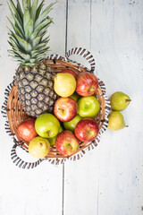 fruits in an arrangement on a white wooden surface with a white background. Top view