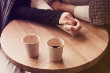Top view of eco friendly recyclable cardboard cups and couple hands putting together. Coffee glass with hot beverage with americano, espresso, ristretto inside on the wooden table. Focus on cups.