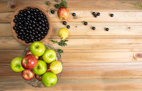 fruits in an arrangement on a light rustic wooden surface with a black background. Top view