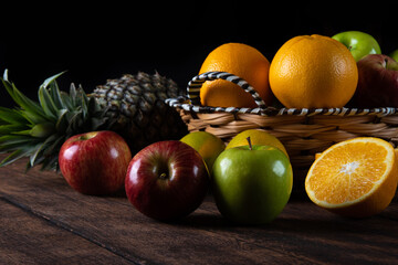 fruits arranged on a rustic wooden surface with a black background. selective focus.