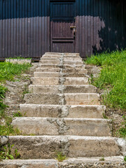 Worn out stone stairs leading to a closed door.