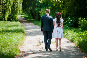 Fototapeta premium The guy with the girl walk in the summer park