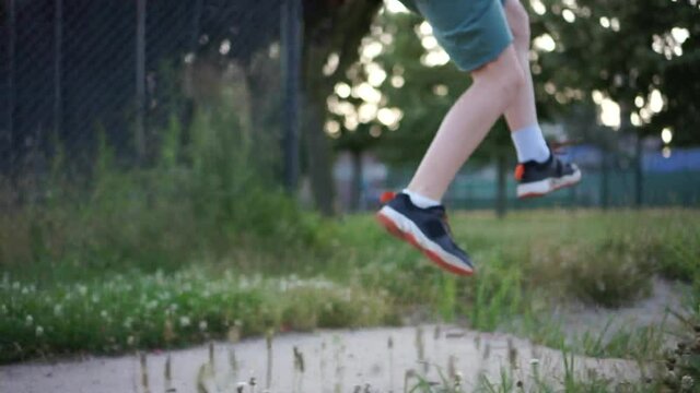 Long jump. Close-up of a schoolboys leg. The boy takes a run and jumps in length on the sand. Physical education lessons at school