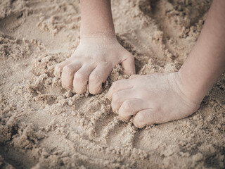 Hands of a Asian young child playing with the sand. Preschool learning concept