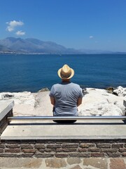 Wakacyjny letni dzień, mężczyzna w słomkowym kapeluszu. Gaeta, Italia. - obrazy, fototapety, plakaty