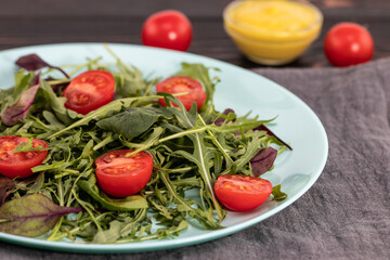 arugula salad and tomatoes on a wooden background