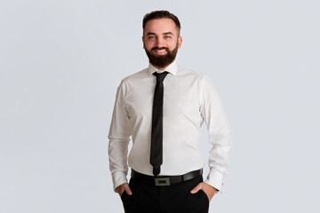 Smiling corporate employee in white shirt and tie against grey background