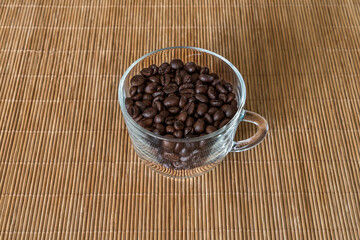 Roasted coffee beans in a transparent glass cup