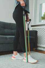 Woman doing exercises with resistance bands at home.