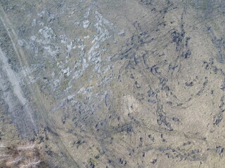 Traces of construction equipment on the soil, aerial view. Lifeless land, wasteland.