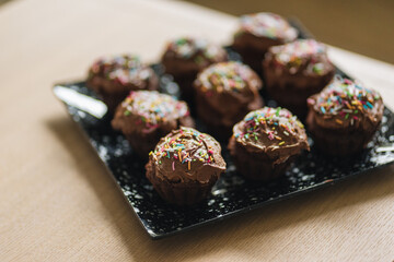 Chocolate muffins on the wooden table and a chocolate cream on top