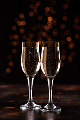 selective focus of glasses full of champagne against christmas lights