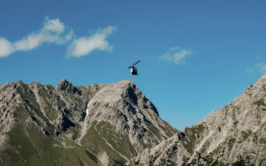Helicopter flying over the rocky Mountains during a sunny sunset. Aerial Landscape from Austrian...