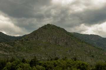 A lonely peak surrounded by mountains