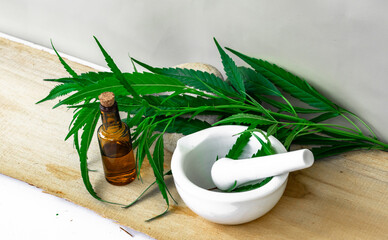 Green cannabis leaves isolated on white stone in wooden background. Growing medical marijuana.