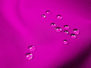 Purple waterproof fabric with drops close up after rain