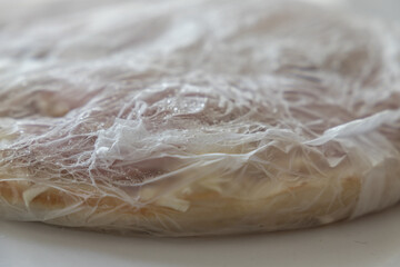 frozen pizza in plastic sheet