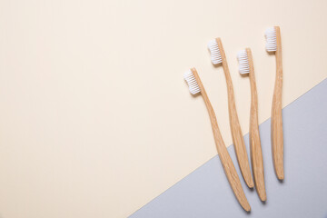 Four eco bamboo toothbrushes on grey and cream background