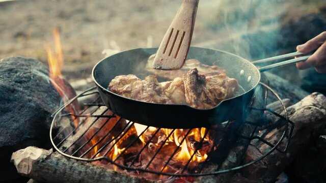 Cooking chicken over a campfire