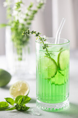 Summer green drink, lemonade with lime, basil and ice in a glass