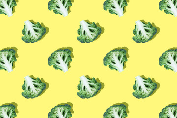 Seamless regular pattern of broccoli slices on bright yellow background.Top view.Photo collage,hard light,shadow,pop art design. Food blog, vegetable background. Printing on fabric, wrapping paper.