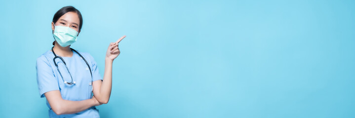 Portrait of young Asian beautiful nurse in blue uniform and wearing a surgical mask for protection...