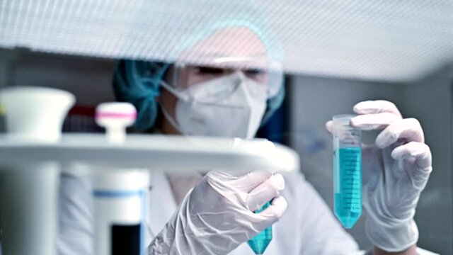 無菌状態の研究所で試験薬を扱う科学研究員