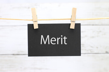 洗濯挟みに吊るされた「merit」のカード