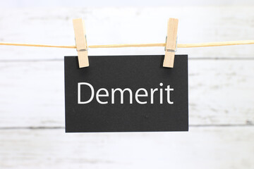 洗濯挟みに吊るされた「demerit」のカード