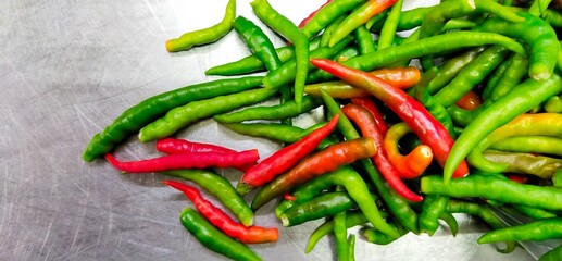
Green and red chillies on a stainless stand