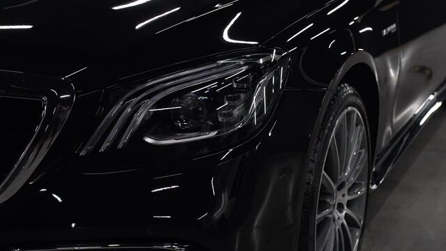 Close up of details of headlights of anonymous prestigious black luxury modern car. Concept of passion for driving cars, car dealerships,luxury cars. Shot in 4K. Head light