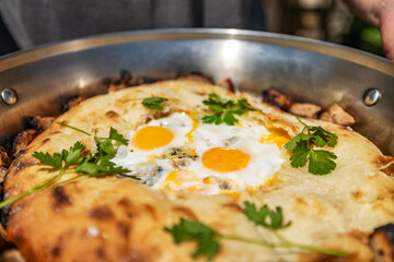 Fresh breakfast fried eggs in pita bread, in a large frying pan, closeup, shallow depth of field, selective focus. Fast breakfast concept