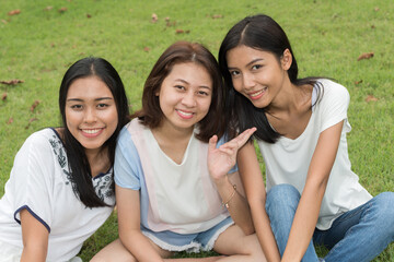 Portrait of three young beautiful Asian teenage girls as friends together at the park