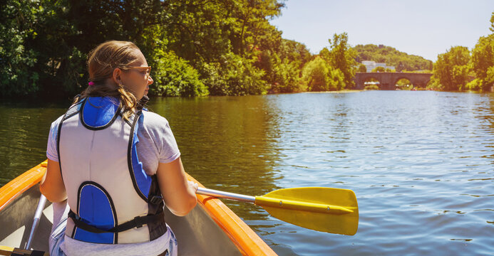 a woman in a canoe enjoys the ride in summer