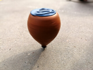wooden spinning top while spinning on the ground