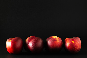 Fototapeta na wymiar Stack of ripe peaches on black background.