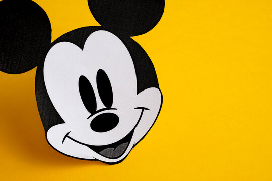 RUSSIA, ST.PETERSBURG - NOVEMBER 19, 2018: Black and white face of Mickey Mouse out of paper on a yellow background.