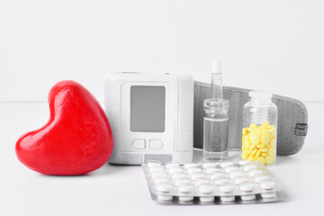 Medical composition. Red heart, tonometer, glass medical bottles, blister pack of tablets on a...