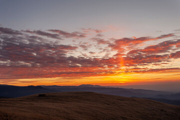 Fototapeta na wymiar Mountain sunrise under a blanket of red clouds.