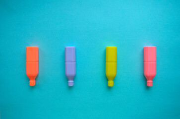 Markers of neon colors on a blue background. Yellow, pink, orange, purple