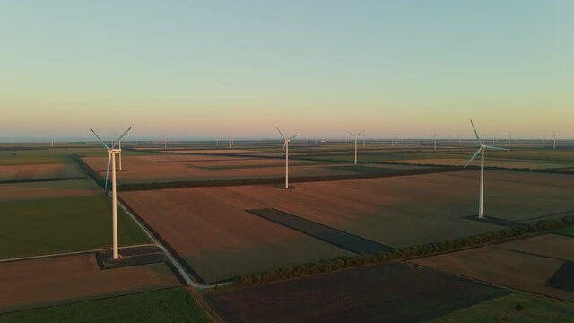 Cinematic footage of wind turbines generating green energy while the sun is setting near Shabla, Bulgaria