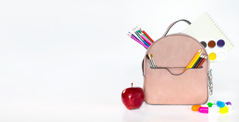 Concept back to school. Full beige School Backpack with scissors, brushes, colored pencils, notebook, colors, markers, on white background. Flat lay.