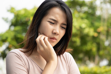 woman with toothache; sick asian woman suffering from toothache, tooth decay, tooth sensitivity,...