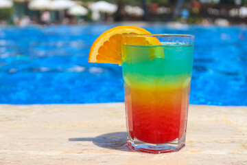 Fresh juicy tropical cocktail near the pool. Colorful cocktail, cold drink. Summer concept. Beach vacation and traveling concept. Copy space for text. Close-up