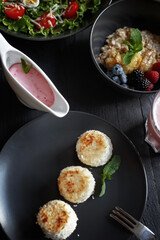 Various culinary dishes on a dark wooden table. Exquisite restaurant serve on dark dishes