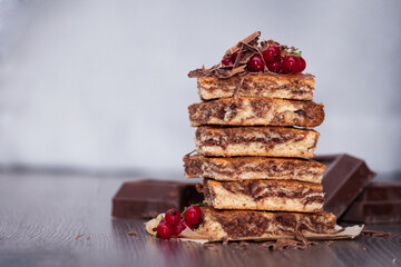 Sweet cake with cocoa powder zebra with berries and chocolate on dark wooden background. Copy space