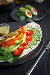 Various culinary dishes on a dark wooden table. Exquisite restaurant serve on dark dishes